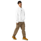 Man wearing a white Under Armour® x Signature embroidered hoodie with relaxed fit and brown cargo pants.