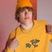 Close-up of My Tackie Tees embroidered logo on men's sweatshirt chest
